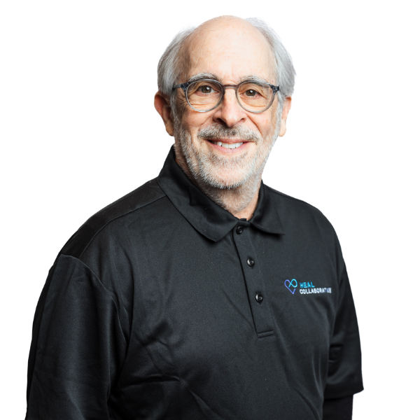 Smiling older man with glasses wearing a black polo shirt.